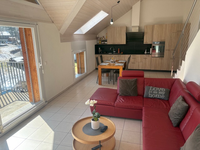 Offener Wohnbereich mit Küche und rotem Sofa