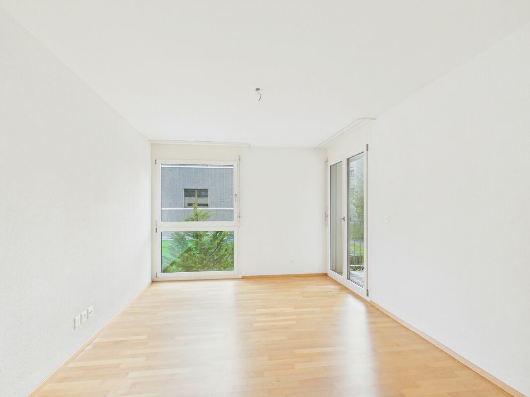 Heller, leerer Wohnraum mit Fensterfront