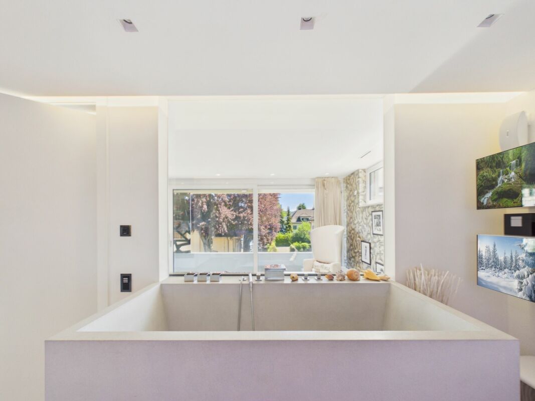 Modernes Badezimmer mit großer Wanne und Gartenblick
