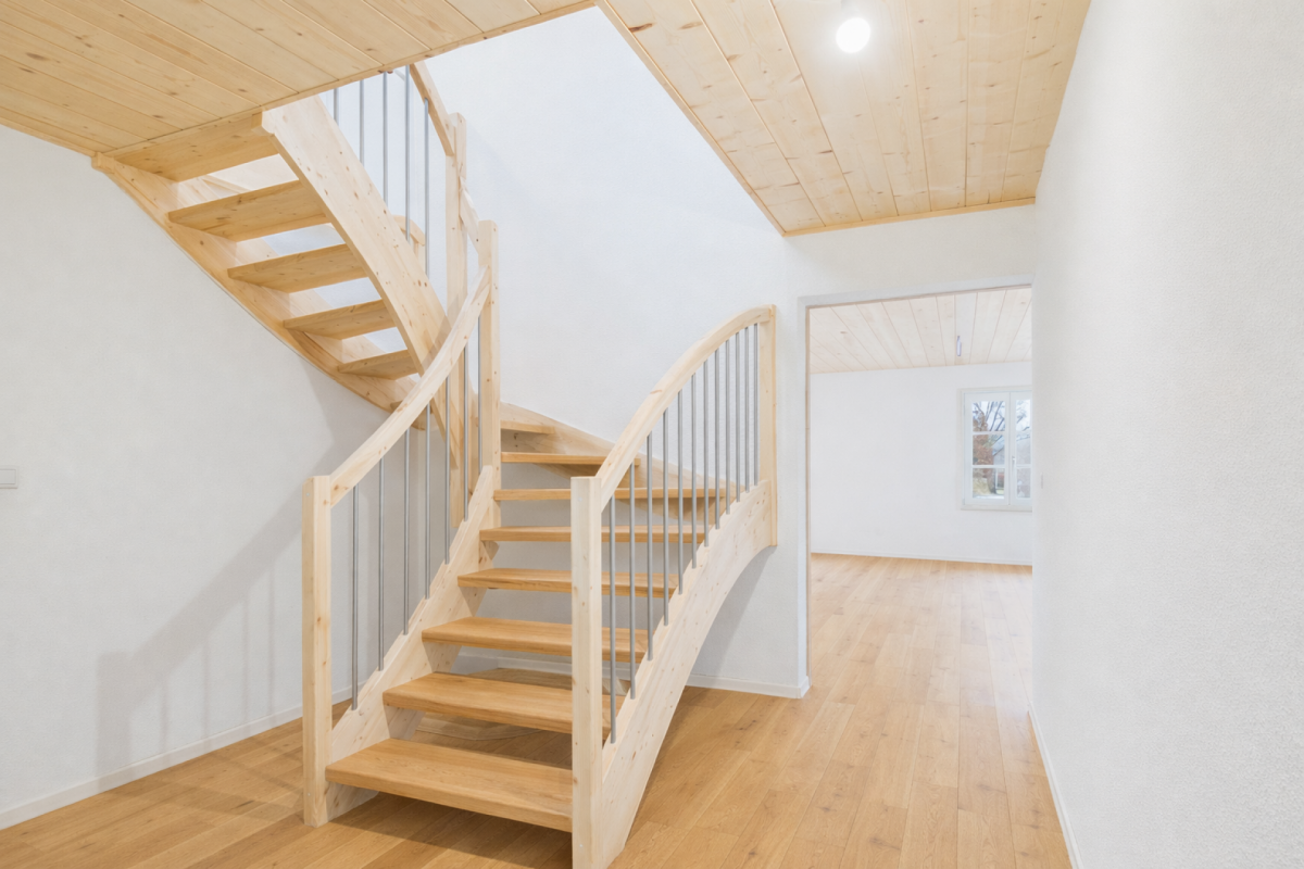 Helles Treppenhaus mit Holztreppe