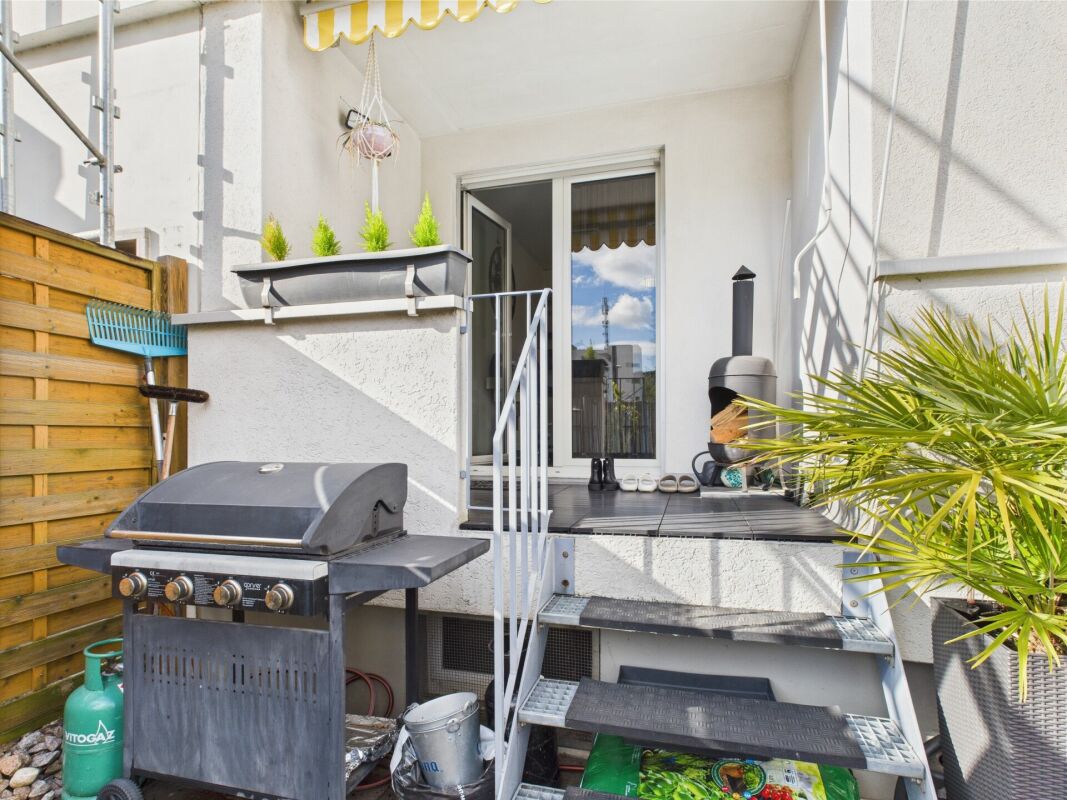 Terrasse mit Grill und Zugang zur Wohnung