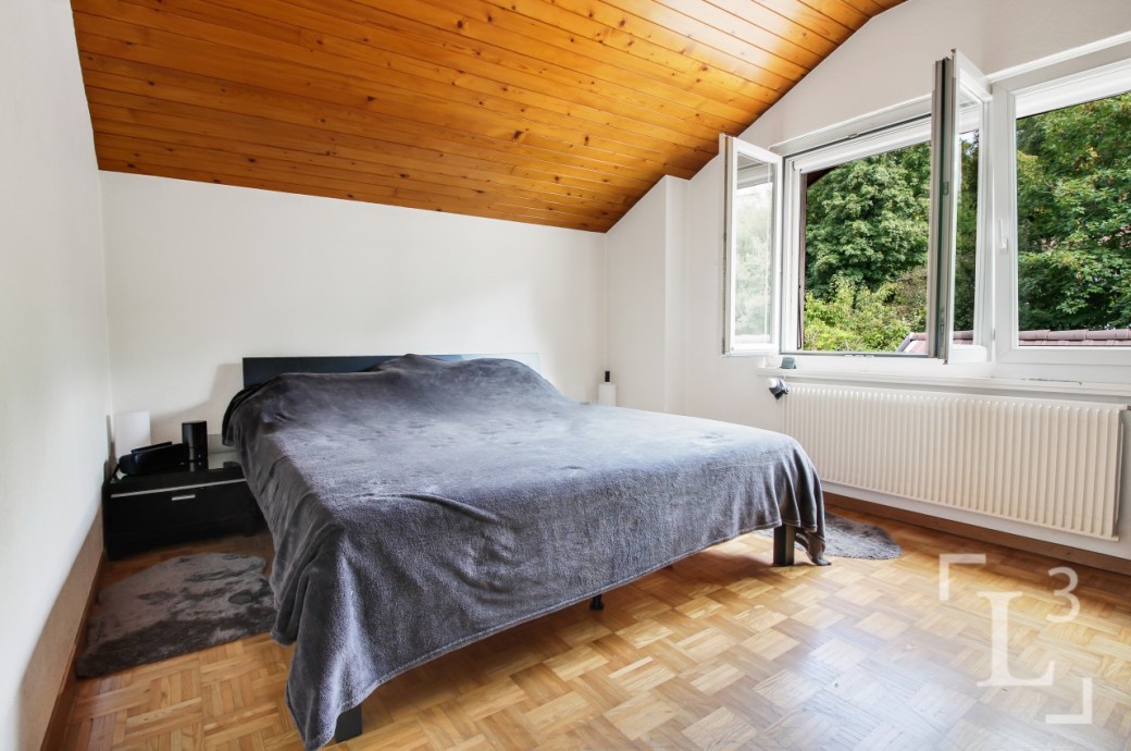 Schlafzimmer mit Holzdecke und offenem Fenster