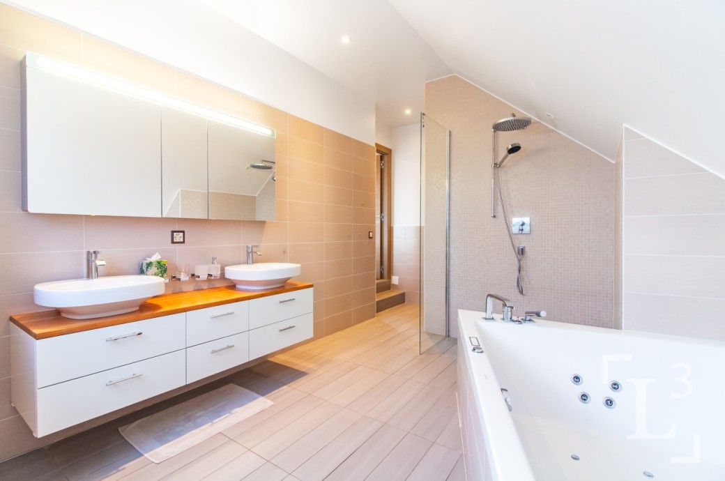 Helles Badezimmer mit Doppelwaschtisch und Badewanne