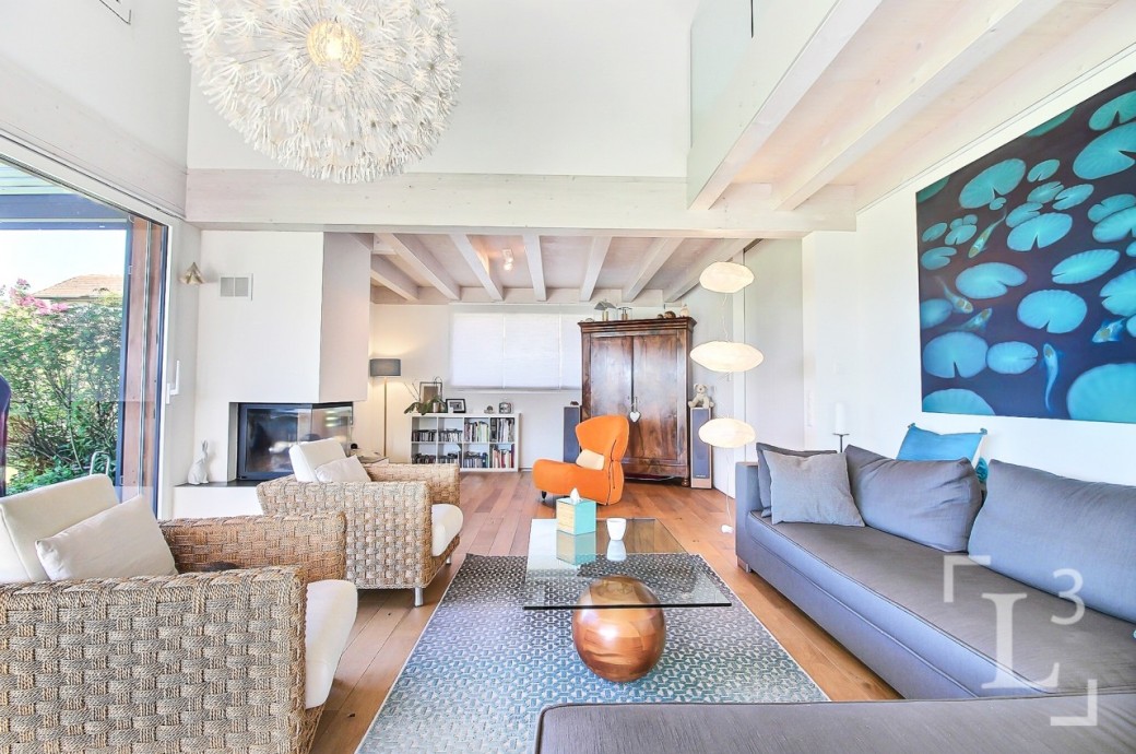 Helles Wohnzimmer mit hoher Decke und großen Fenstern