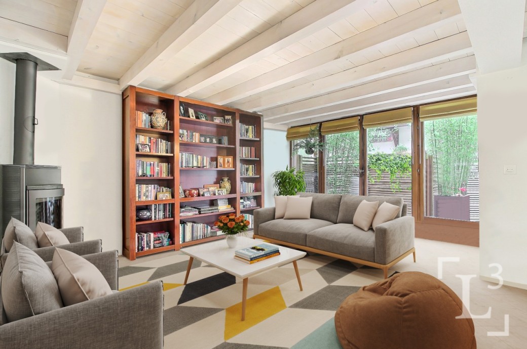 Heller Wohnraum mit Kamin, Bücherregal und Gartenblick