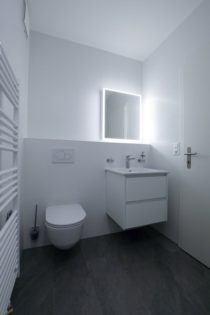 Modernes Gäste-WC mit beleuchtetem Spiegel