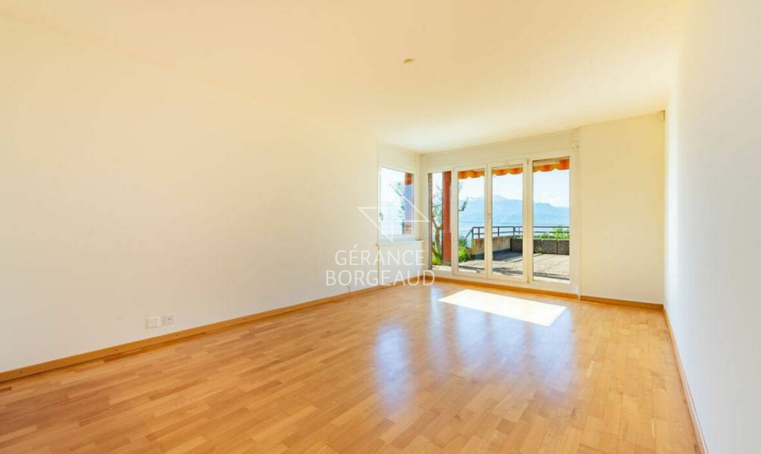 Heller leerer Wohnraum mit Balkon- bzw. Terrassenzugang und Bergblick