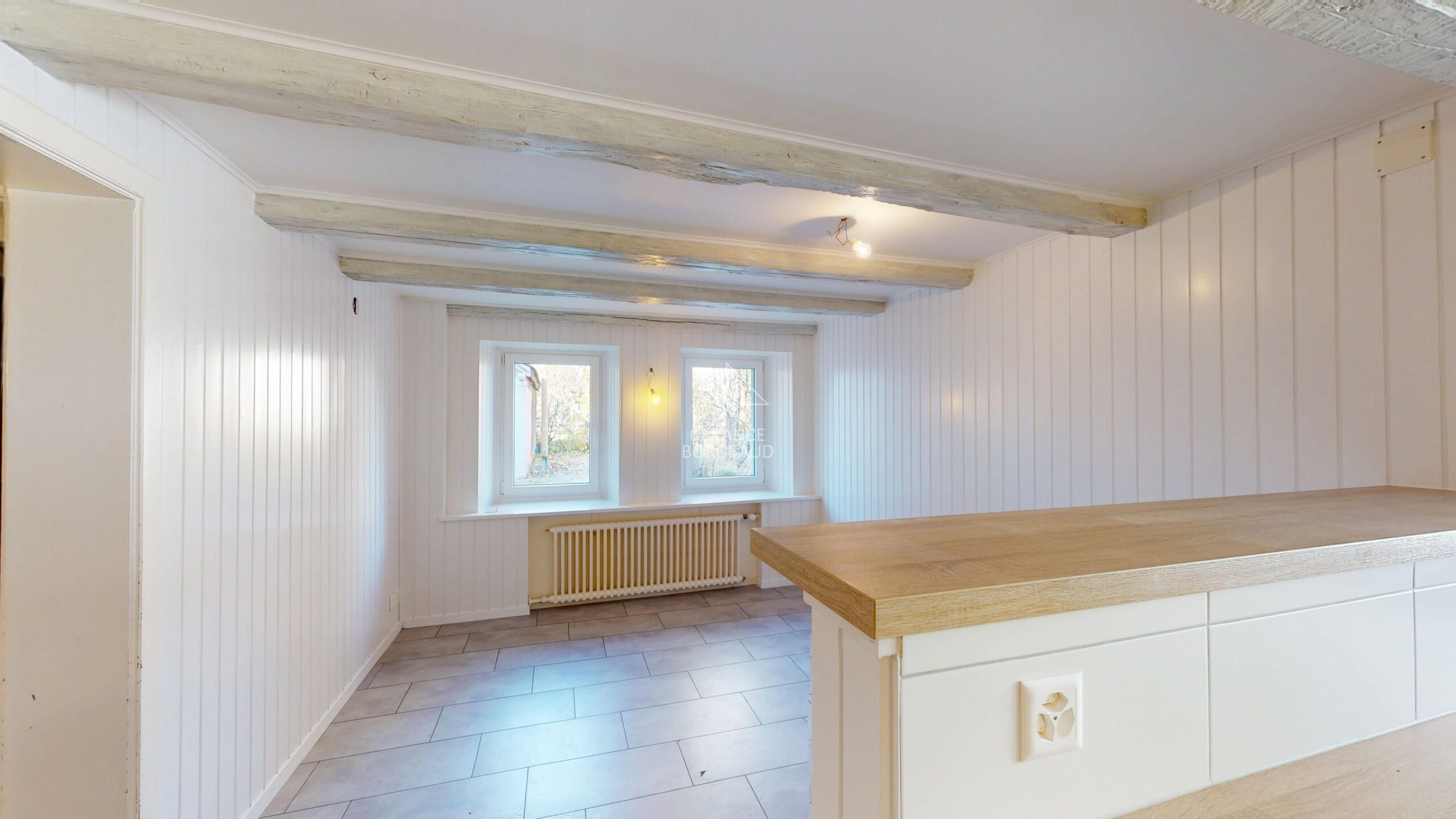 Helles leerstehendes Innenzimmer mit Holzdeckenbalken