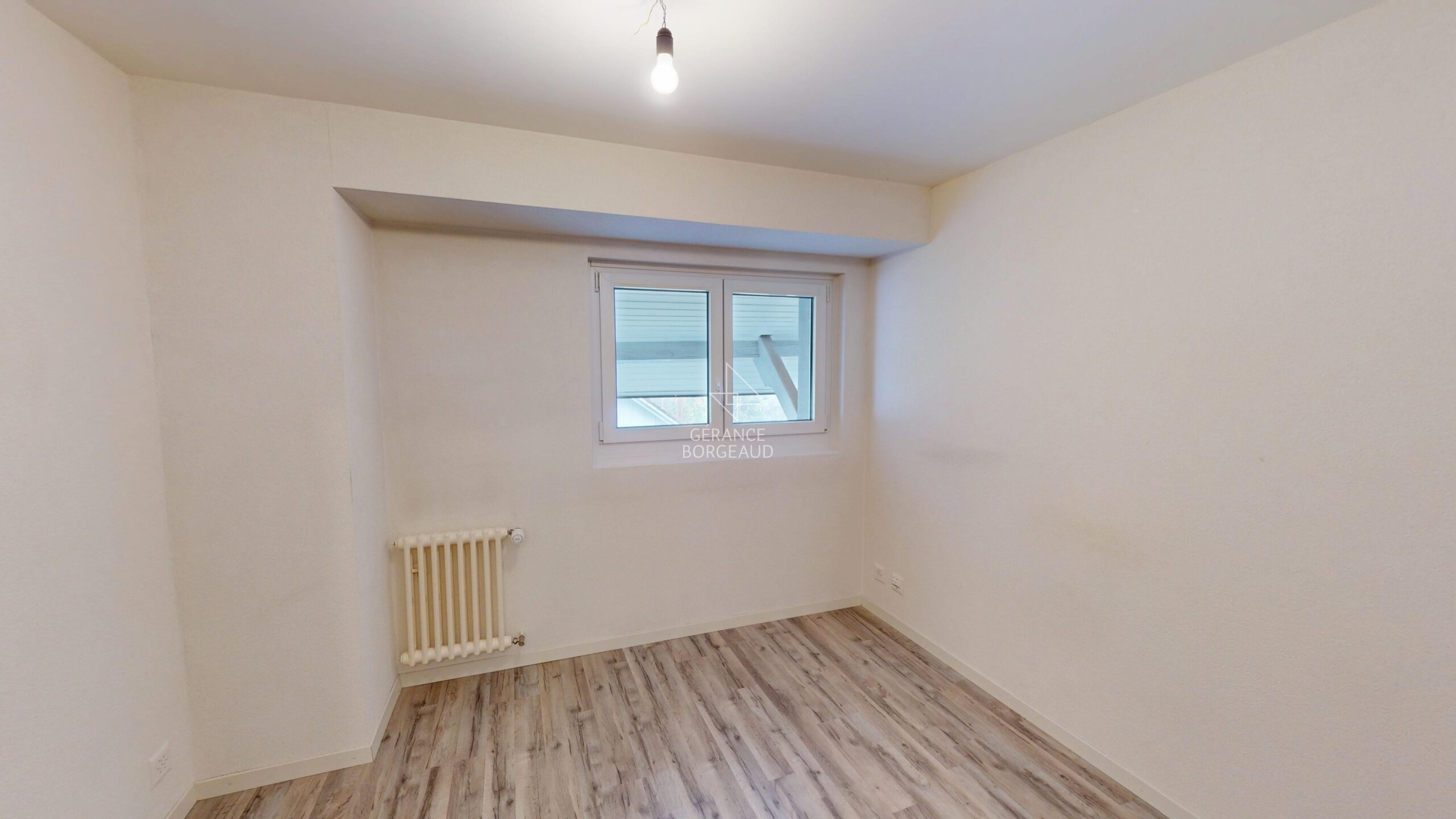 Leerer, renovierter Raum mit Fenster und Heizkörper