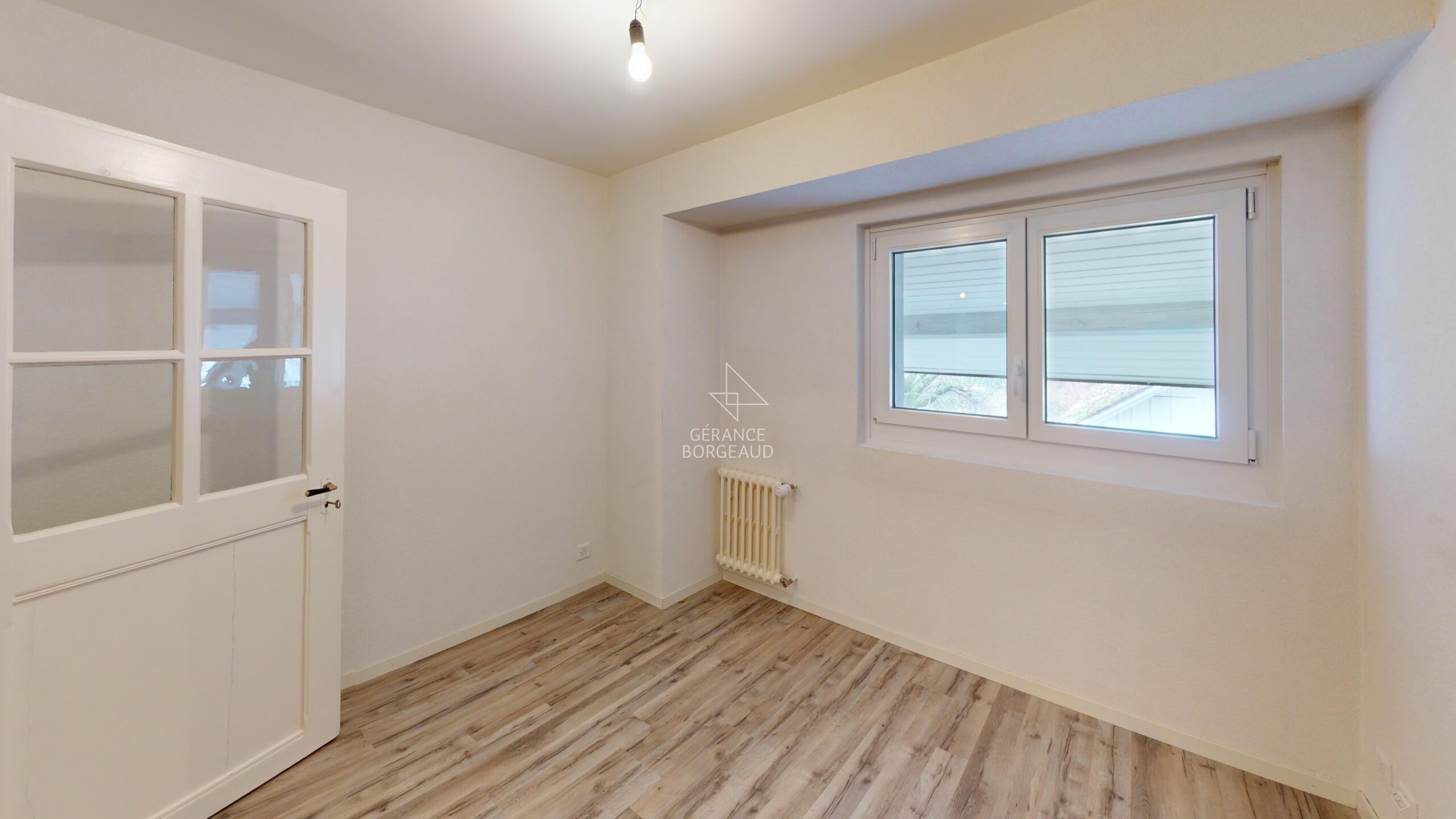 Leeres, helles Zimmer mit Fenster und Innentür