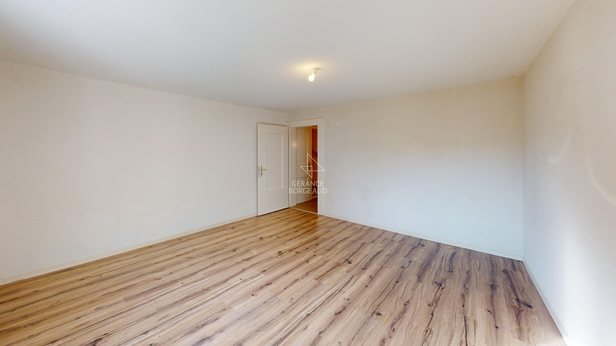 Leerer, renovierter Wohnraum mit Holzoptikboden