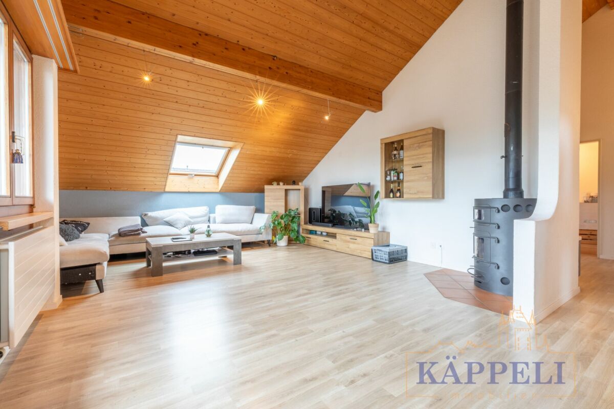 Heller Wohnraum mit Holzdecke und Kaminofen
