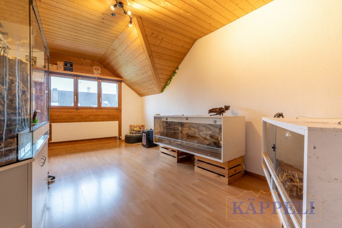 Dachgeschossraum mit Glasvitrinen und Holzdecke