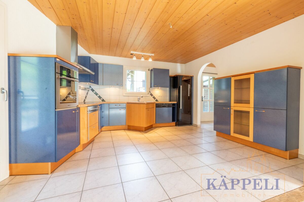Geräumige Küche mit blauen Fronten und Holzdecke