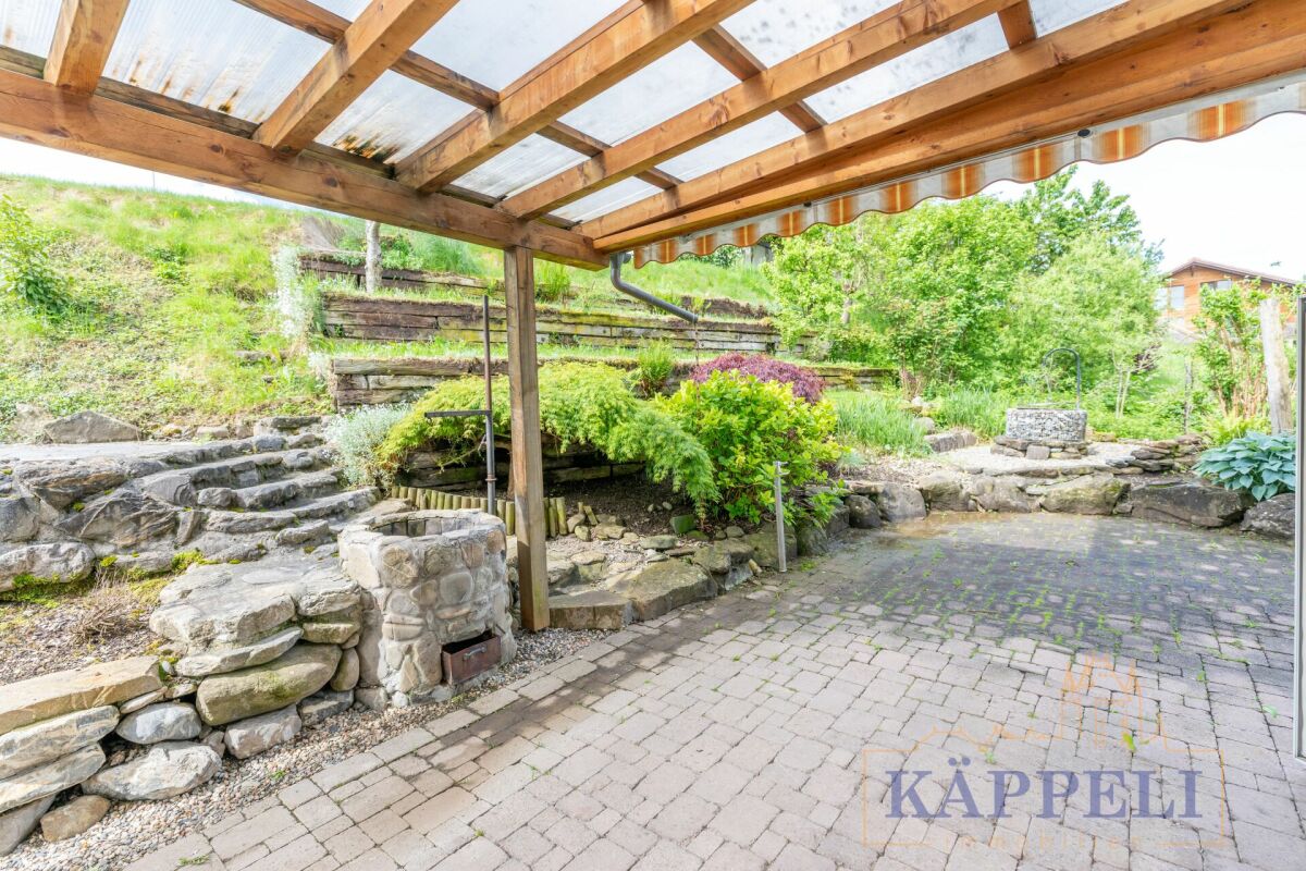 Überdachte Terrasse mit Gartenblick