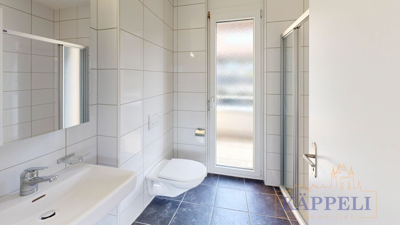 Helles, modernes Badezimmer mit wandhängendem WC und Duschbereich