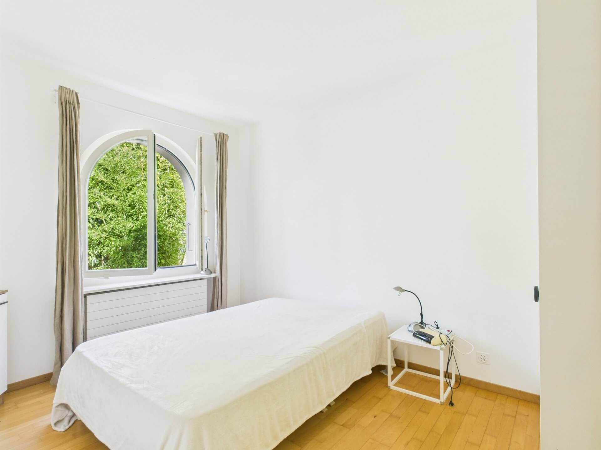 Helles Schlafzimmer mit Rundbogenfenster