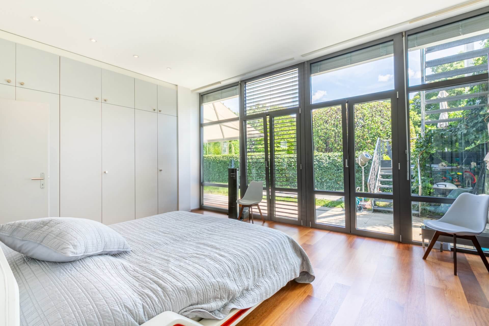 Helles Schlafzimmer mit bodentiefen Fenstern zum Garten