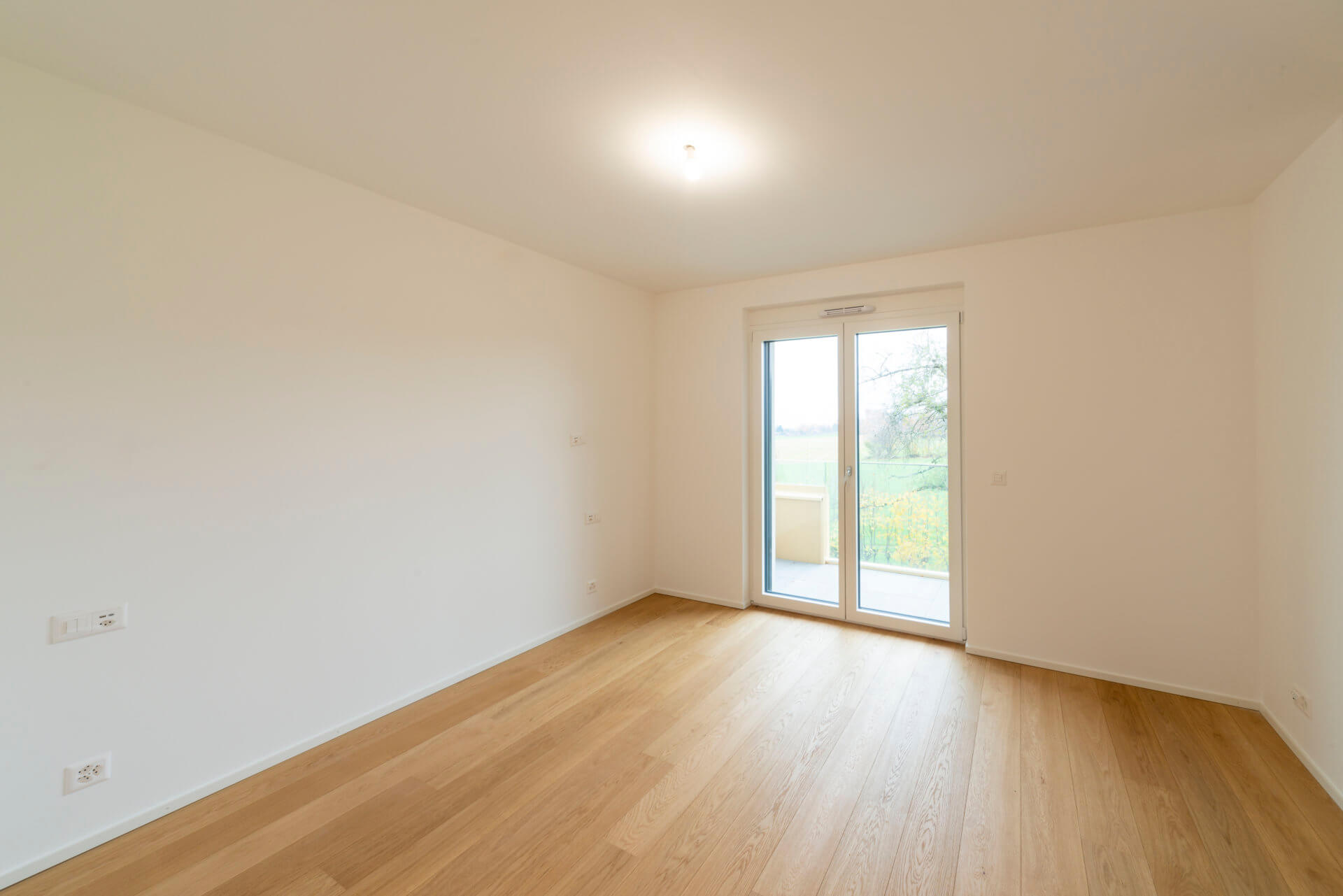 Helles leeres Zimmer mit Balkonzugang