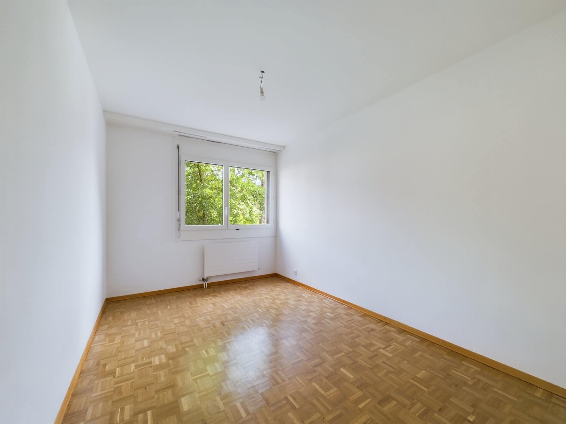 Leeres, helles Zimmer mit Parkettboden