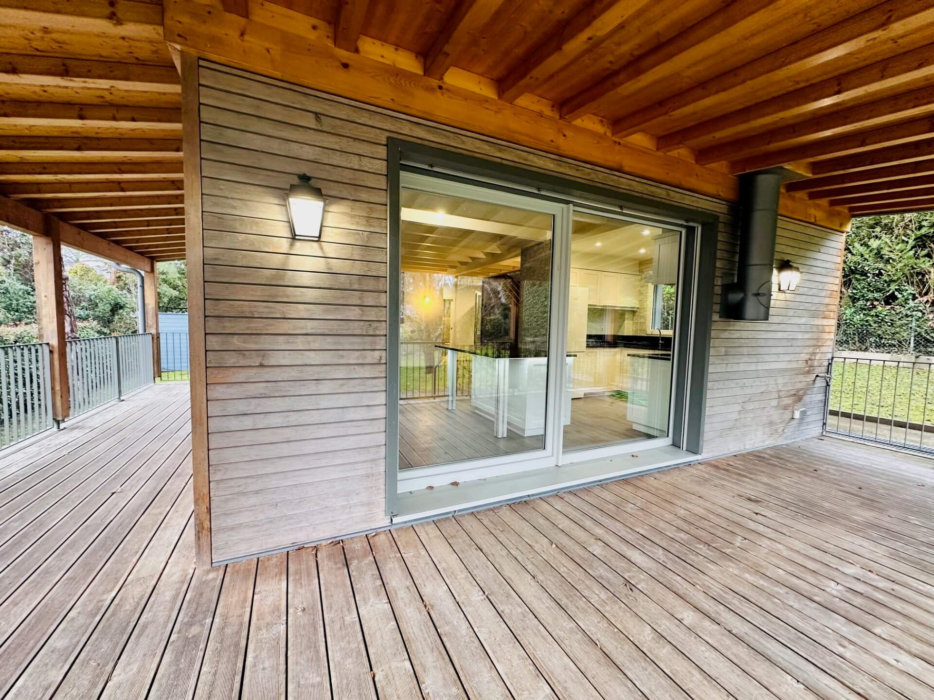 Überdachte Holzterrasse mit Glas-Schiebetür