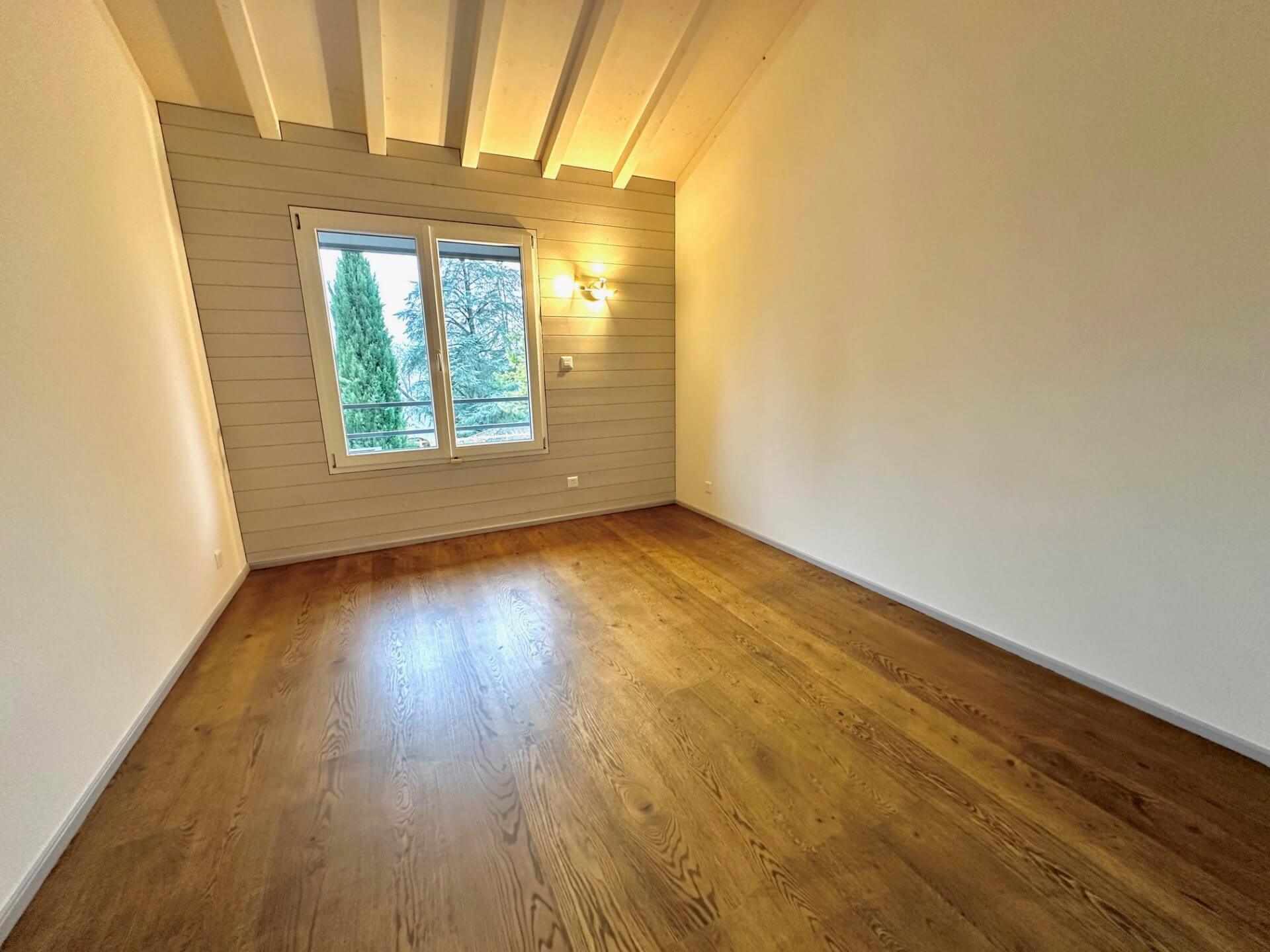 Leerer, hell beleuchteter Wohnraum mit Holzfußboden