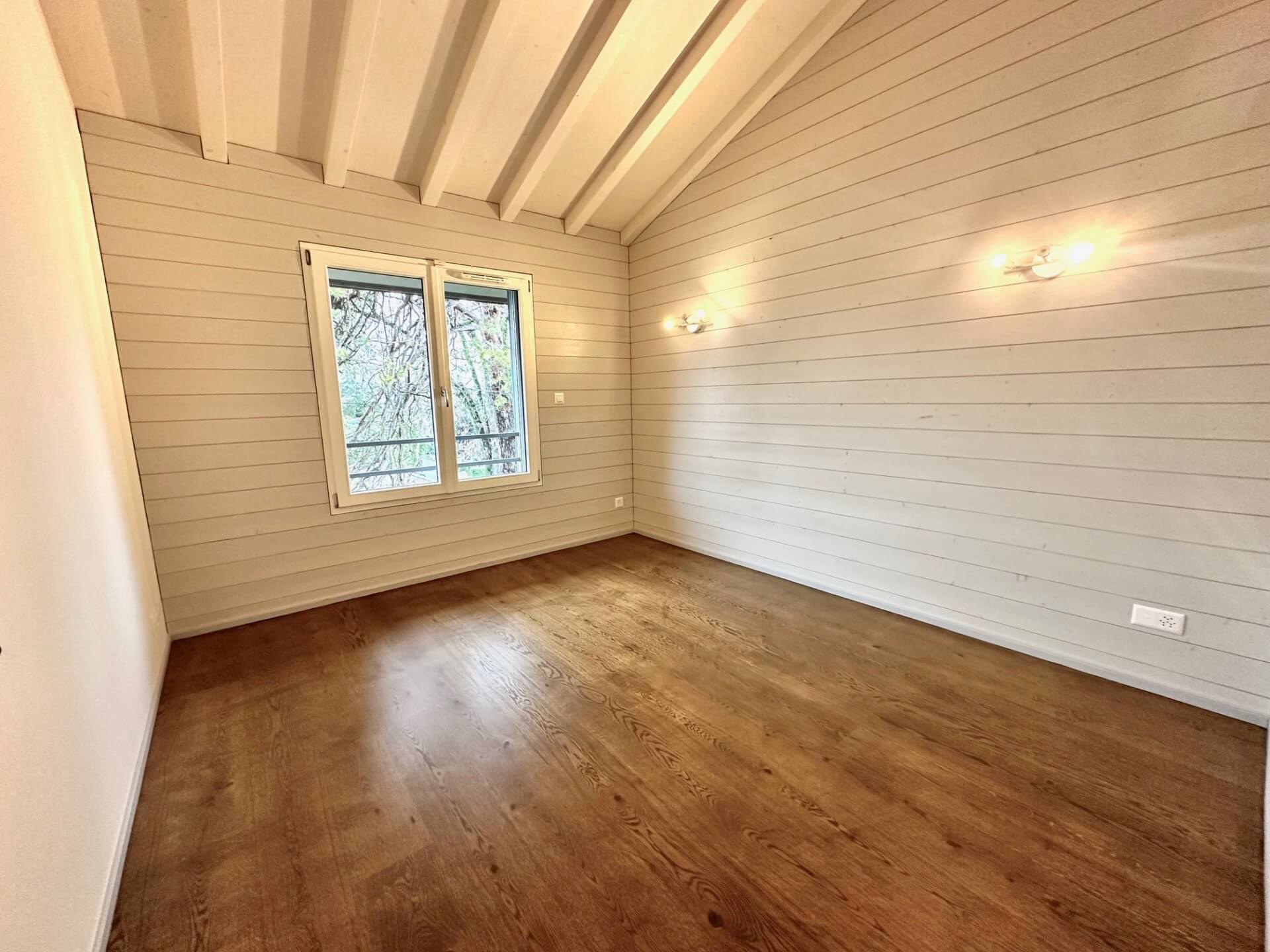 Heller leerer Raum mit Holzdecke und Fenster