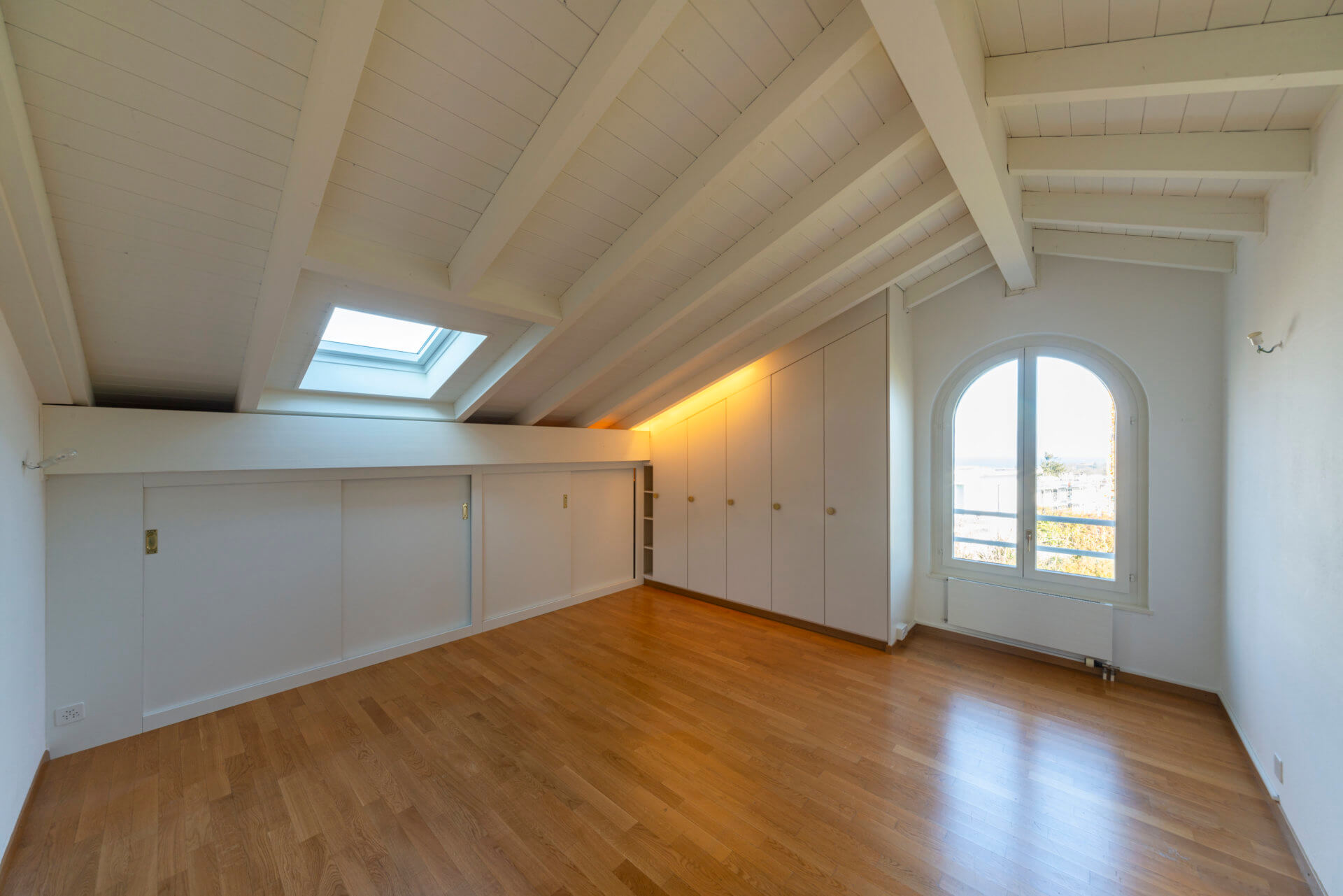 Helles Dachzimmer mit Holzboden und Einbauschränken