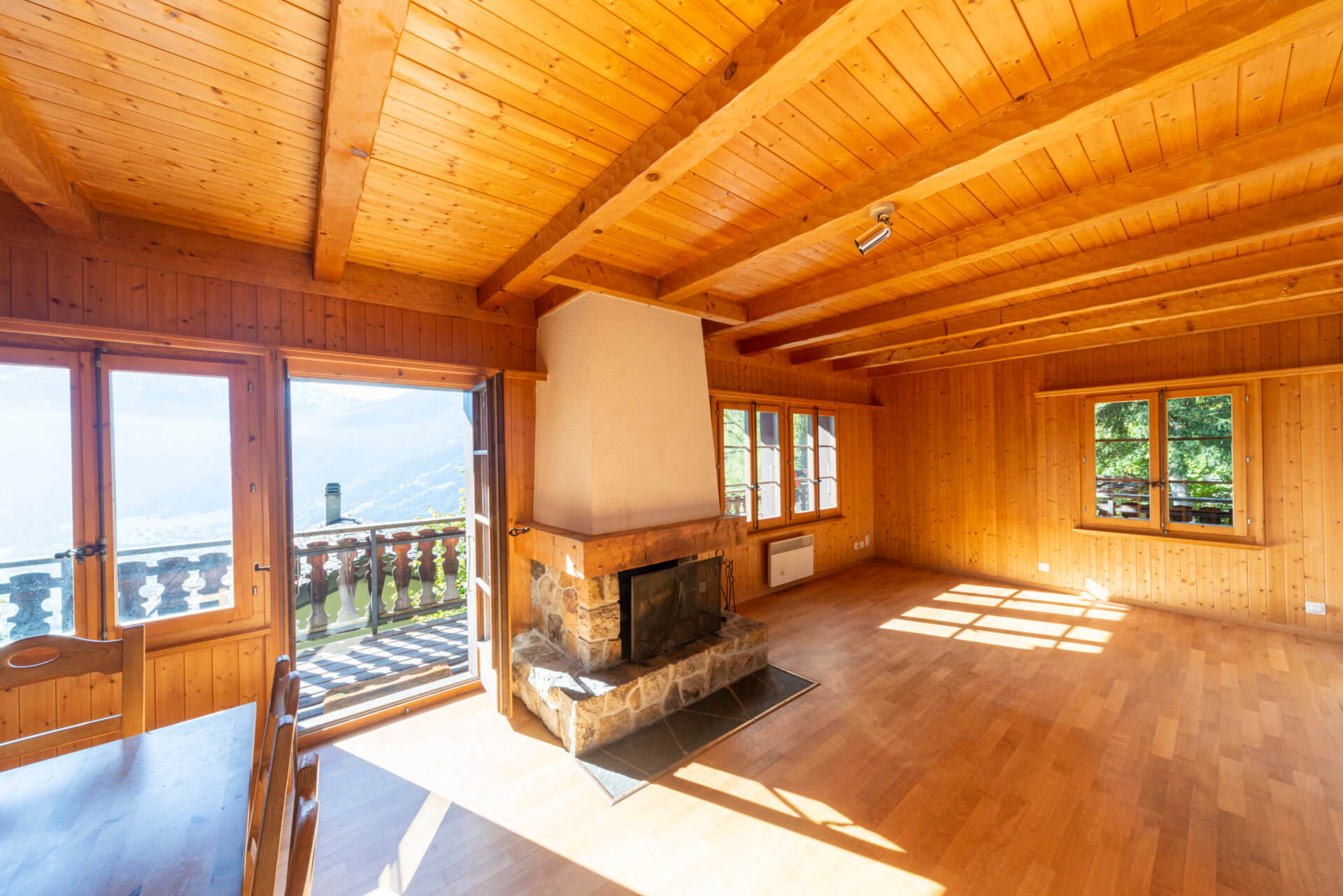Gemütlicher Holzwohnraum mit Kamin und Balkonblick