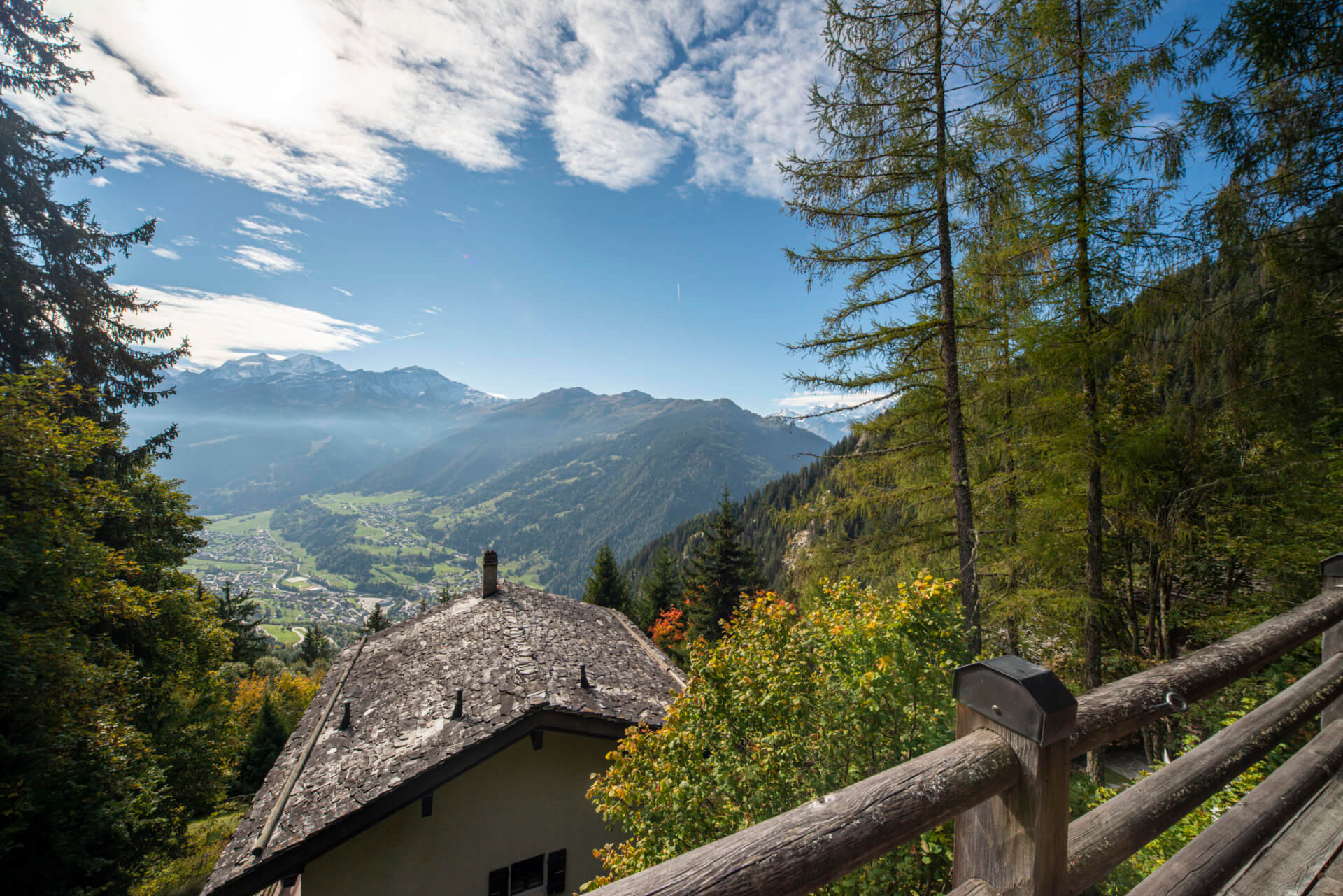 Alpenpanorama mit Hausdach und Holzgeländer