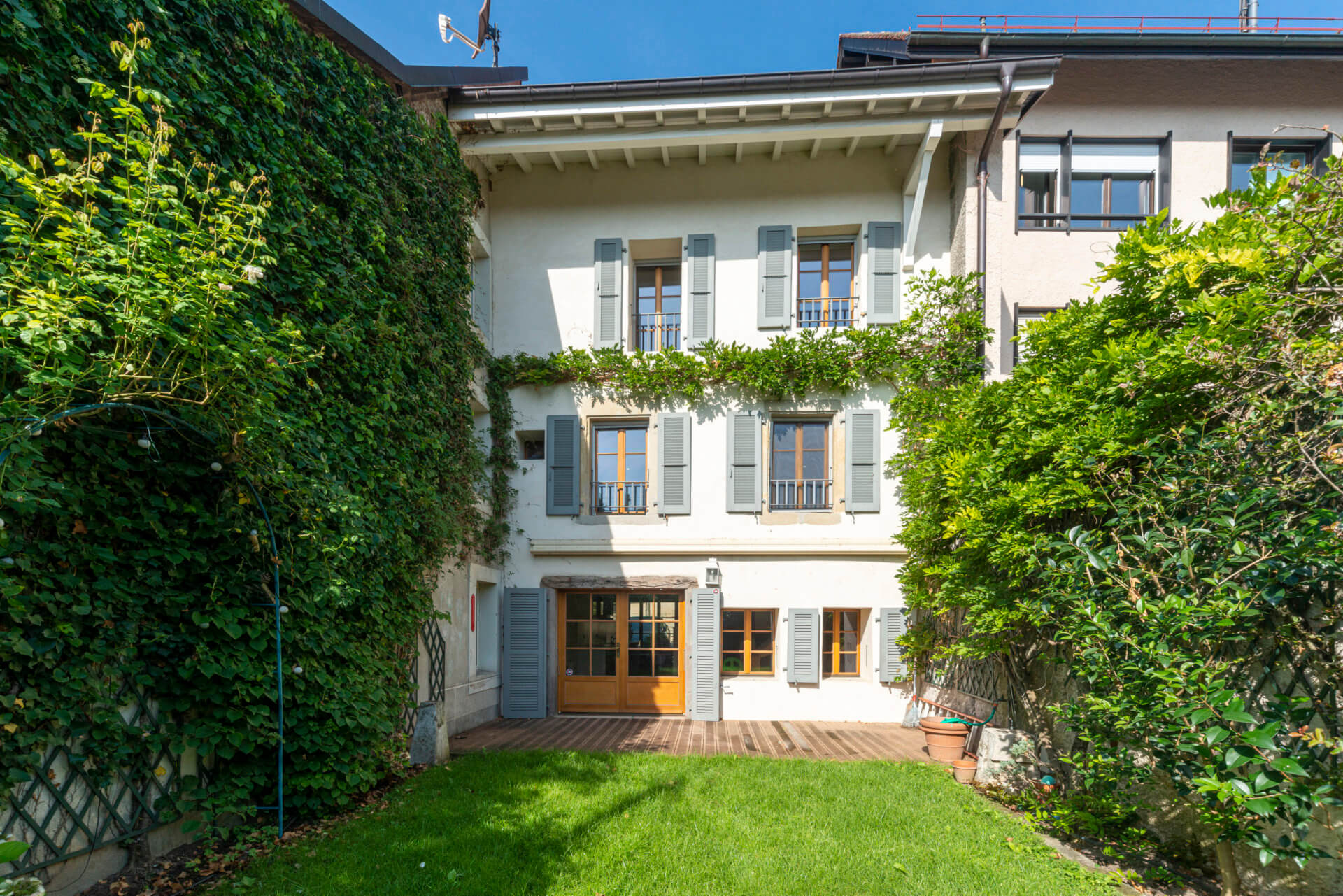 Begrünter Innenhof mit mediterraner Fassade