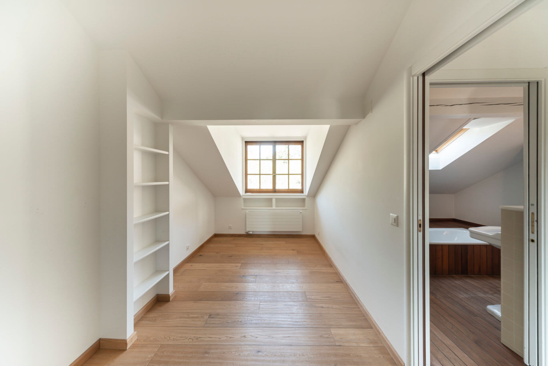 Dachzimmer mit Holzfußboden und Badzugang