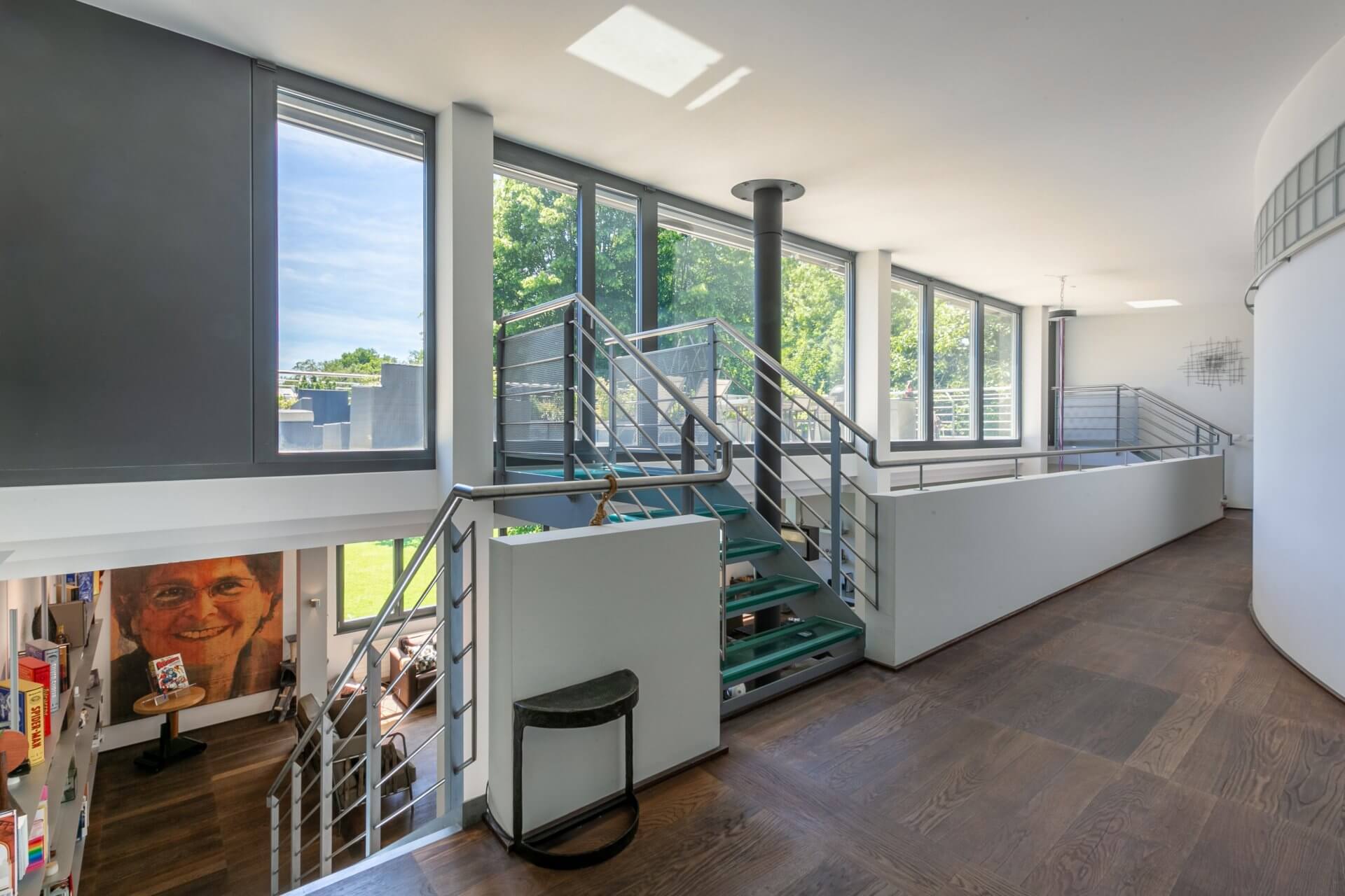 Offener Galeriebereich mit Treppe und großen Fenstern