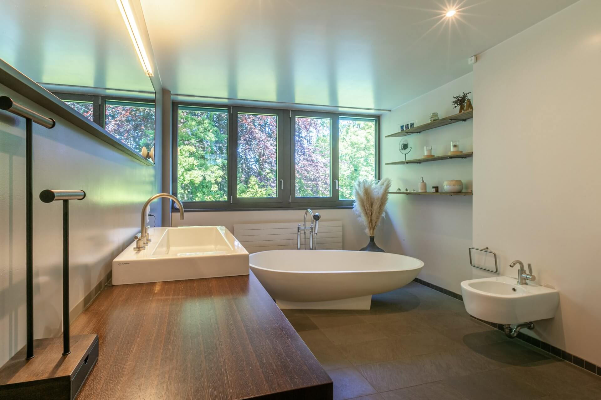 Modernes Badezimmer mit freistehender Wanne und großer Fensterfront