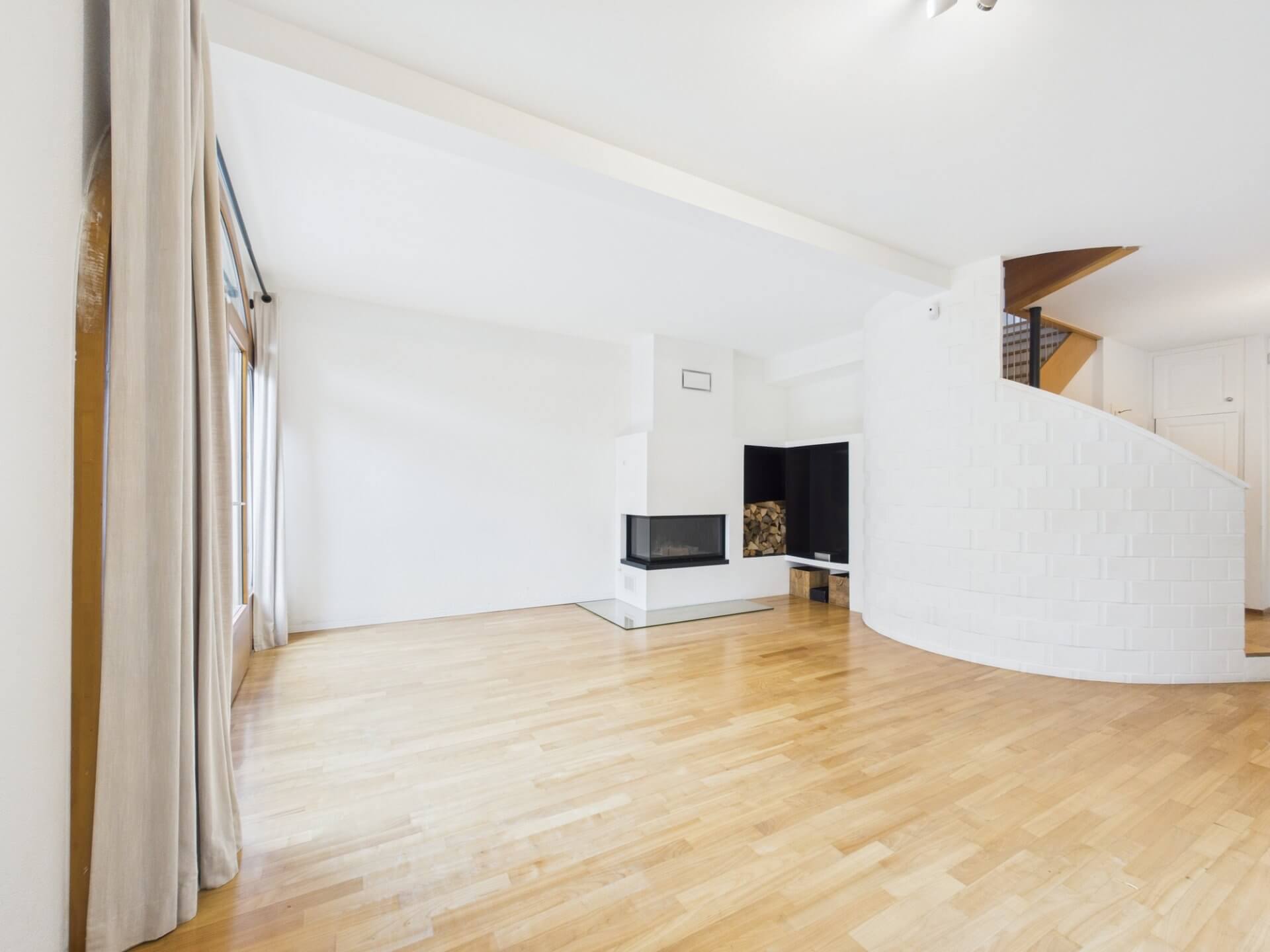 Heller Wohnraum mit Kamin und Holzfußboden