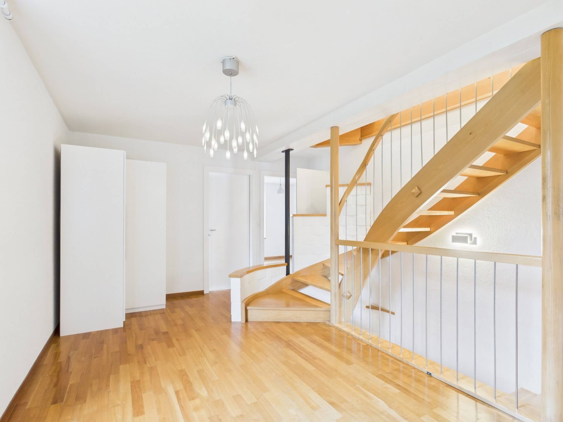 Heller Treppenraum mit Holztreppe
