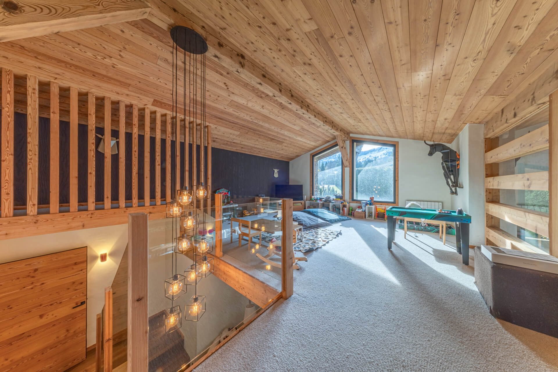 Gemütlicher Dachboden mit Holzverkleidung und Bergblick
