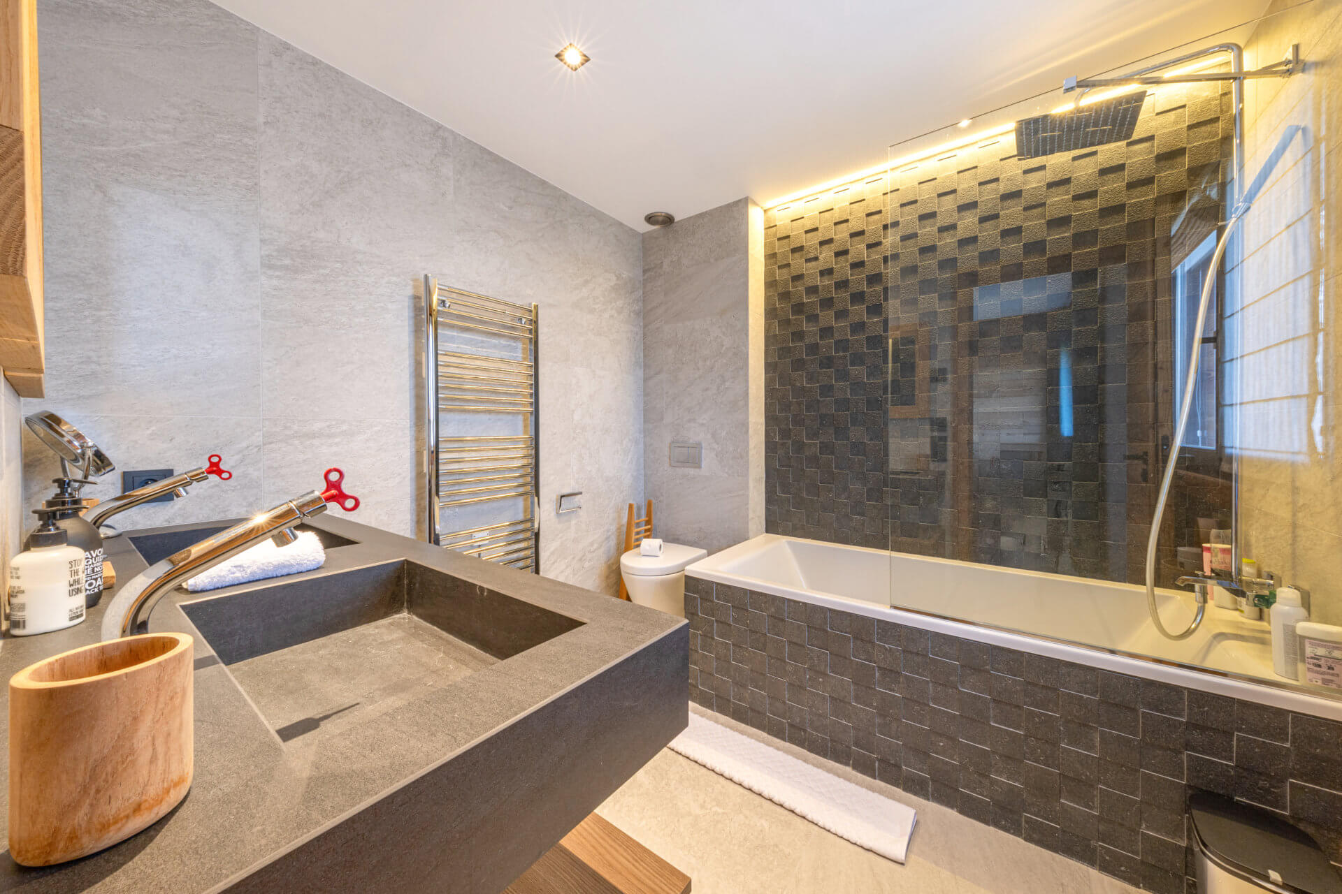 Modernes Badezimmer mit Badewanne und dunkler Duschwand