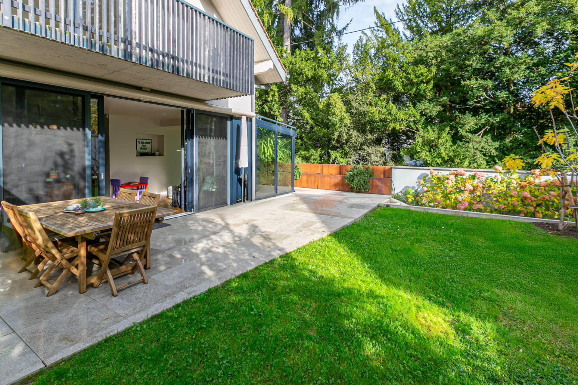 Terrasse mit Garten und moderner Hausfassade