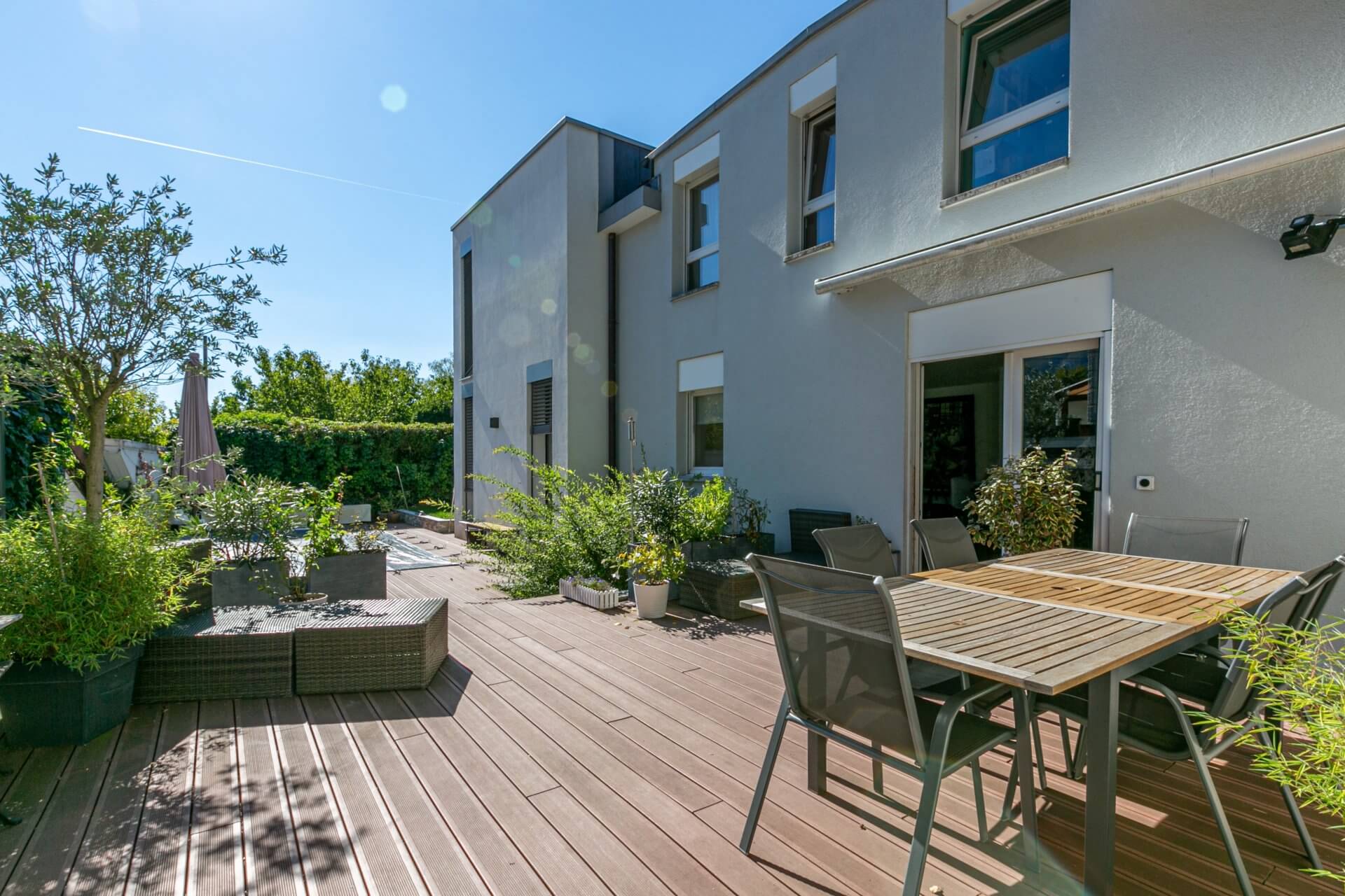 Große sonnige Terrasse mit Gartenmöbeln