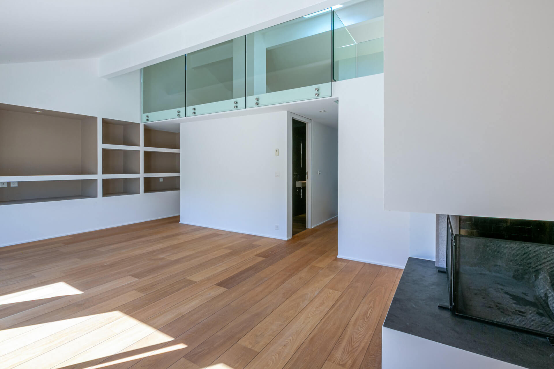 Modernes, offenes Wohnzimmer mit Galerie und Kamin