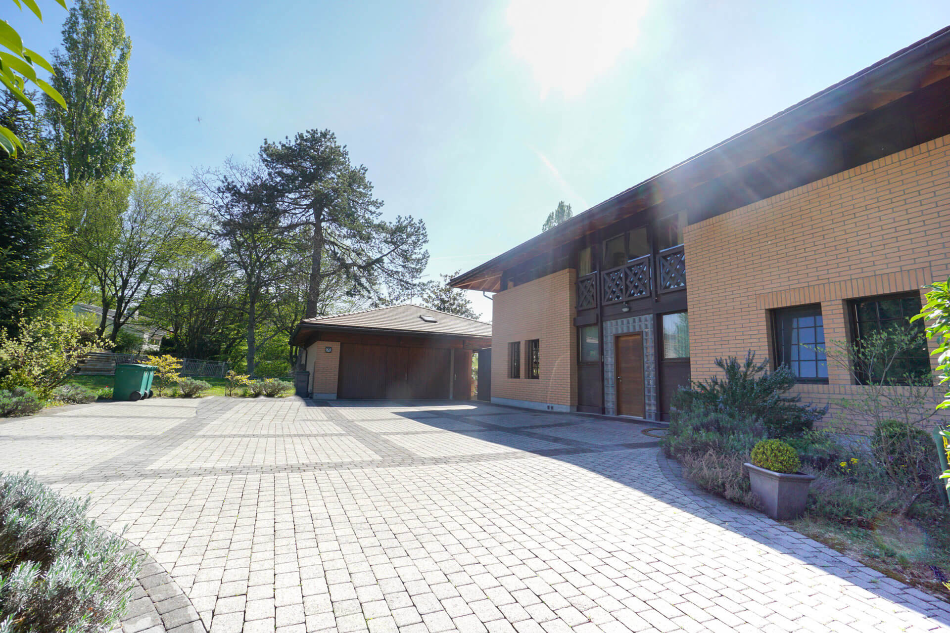Außenansicht einer großzügigen Einfahrt mit Wohnhaus und Garage