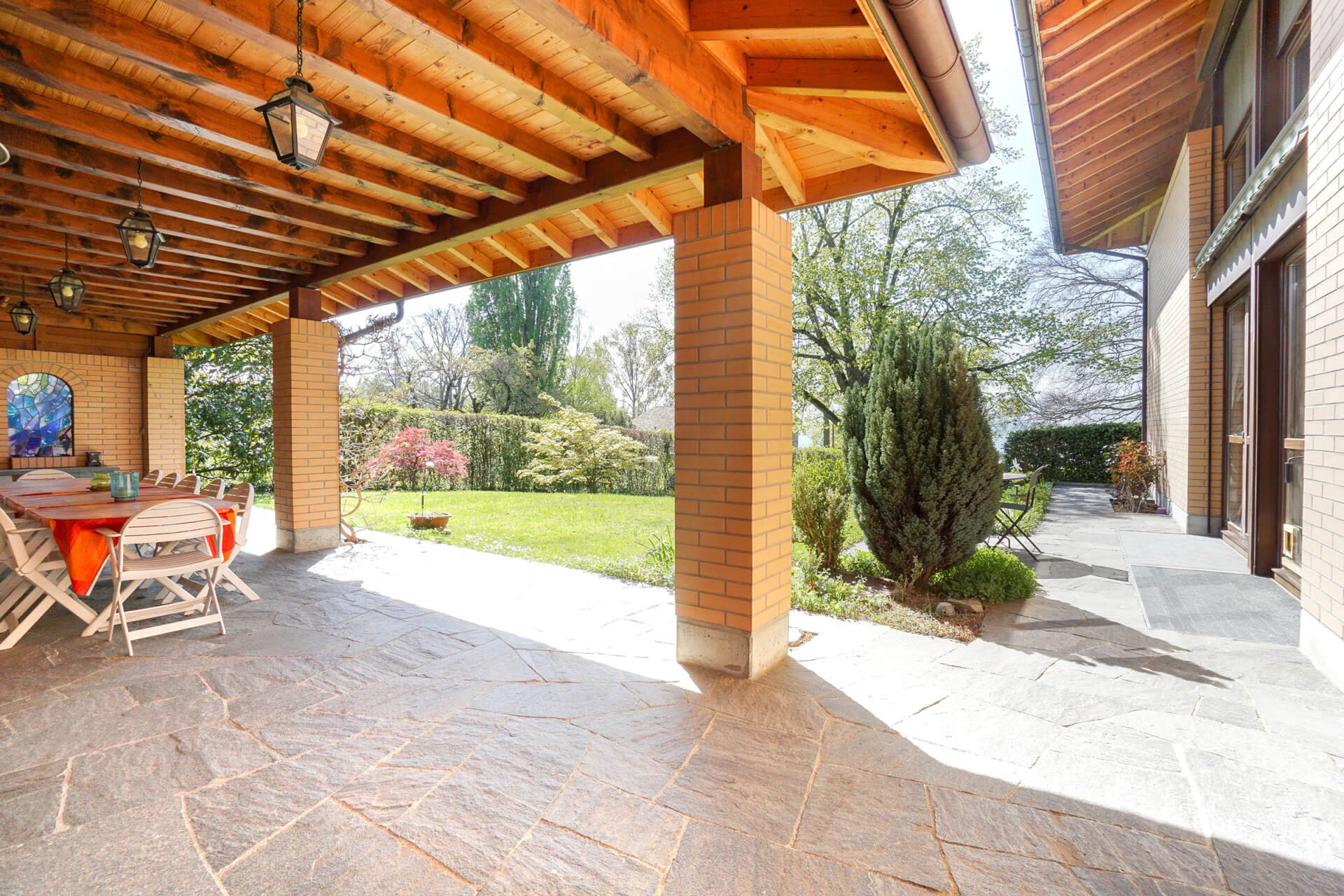 Überdachte Terrasse mit Gartenblick