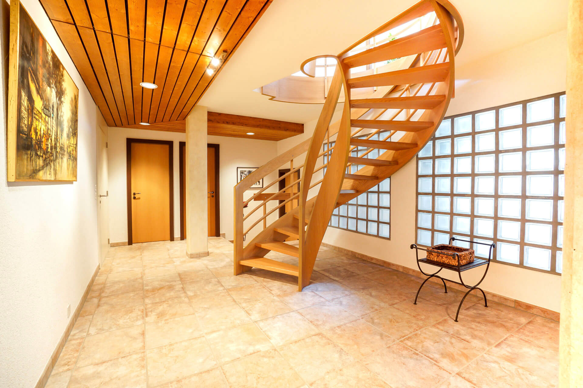 Treppenhaus mit Holztreppe und Glasbausteinwand