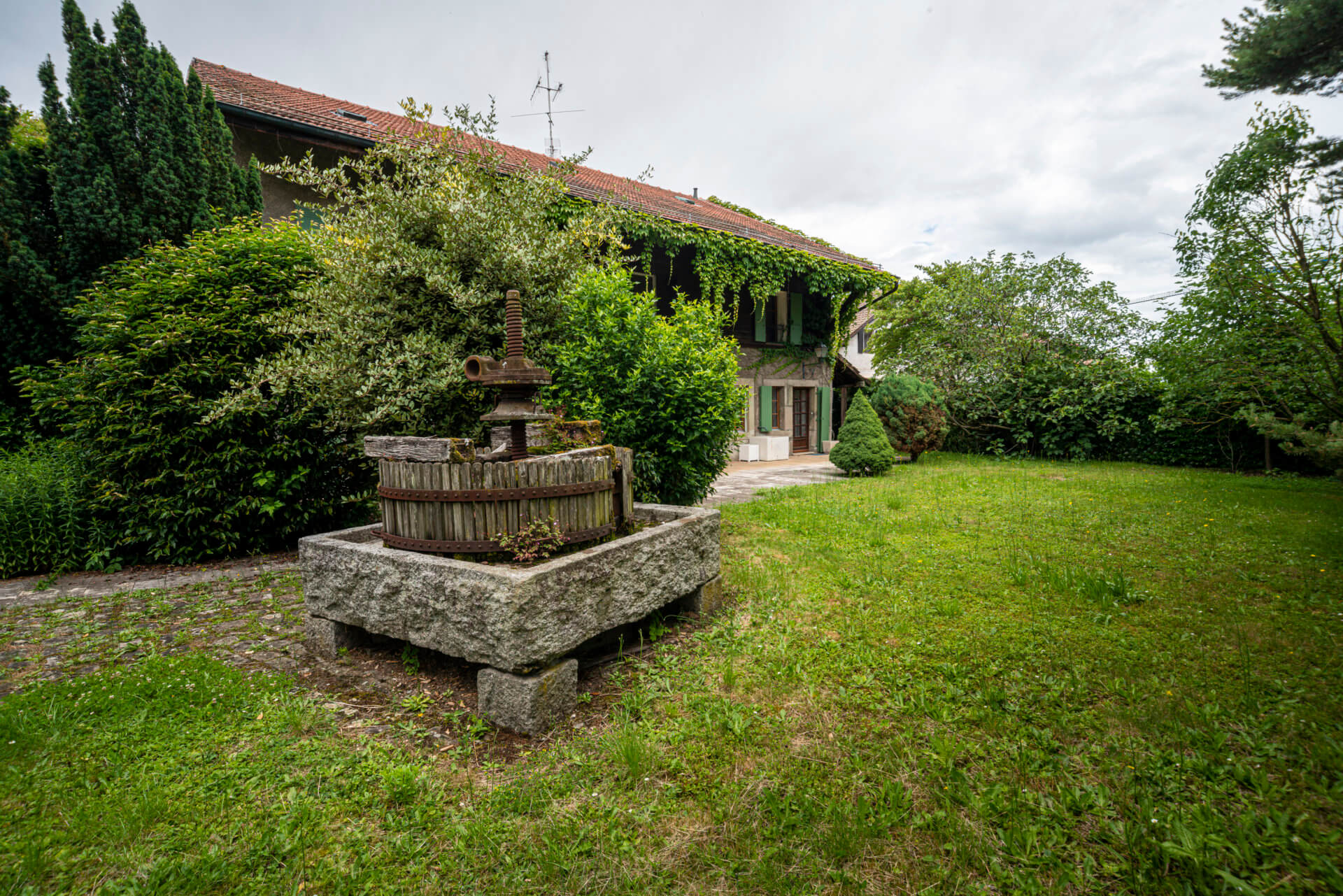 Haus mit großem Garten und Natursteinbrunnen