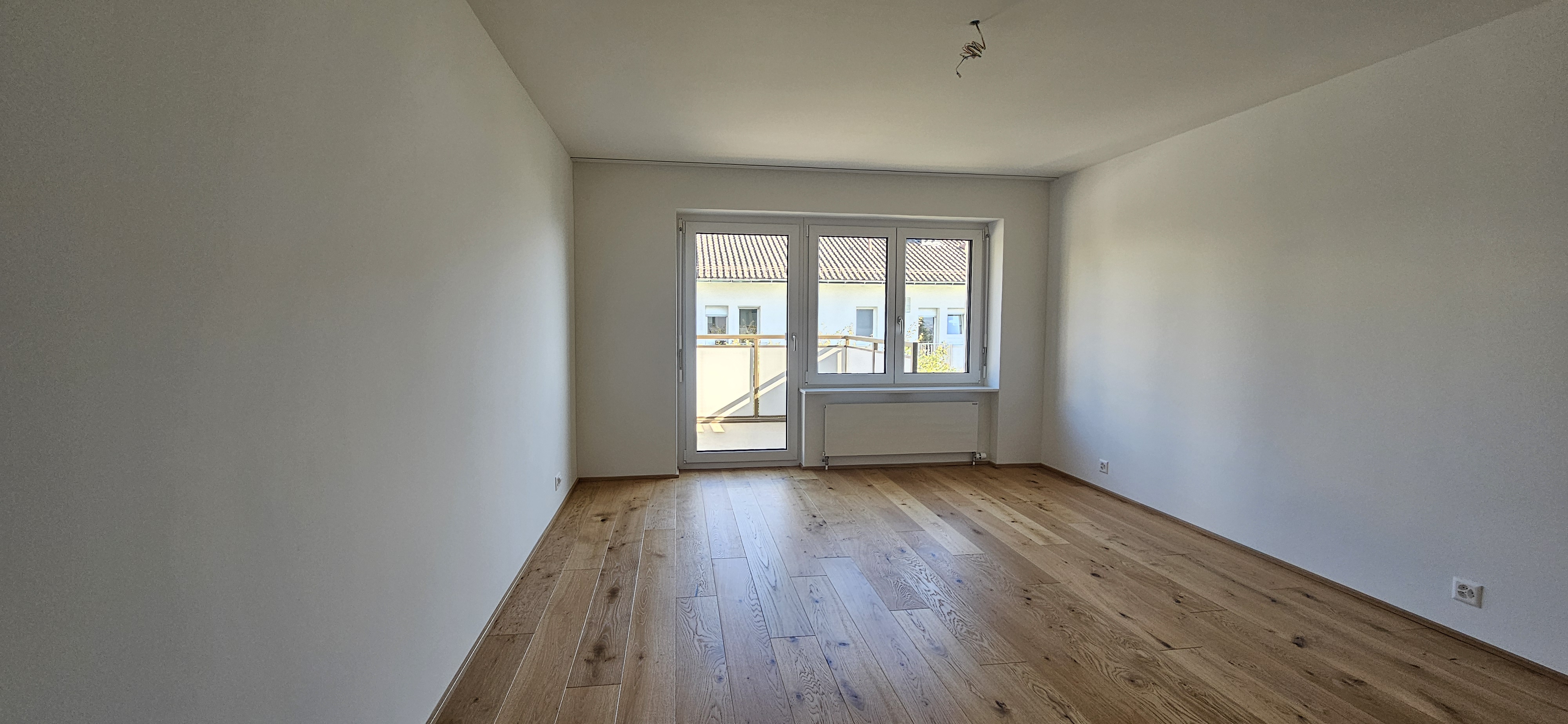 Leerer Wohnraum mit Balkonblick