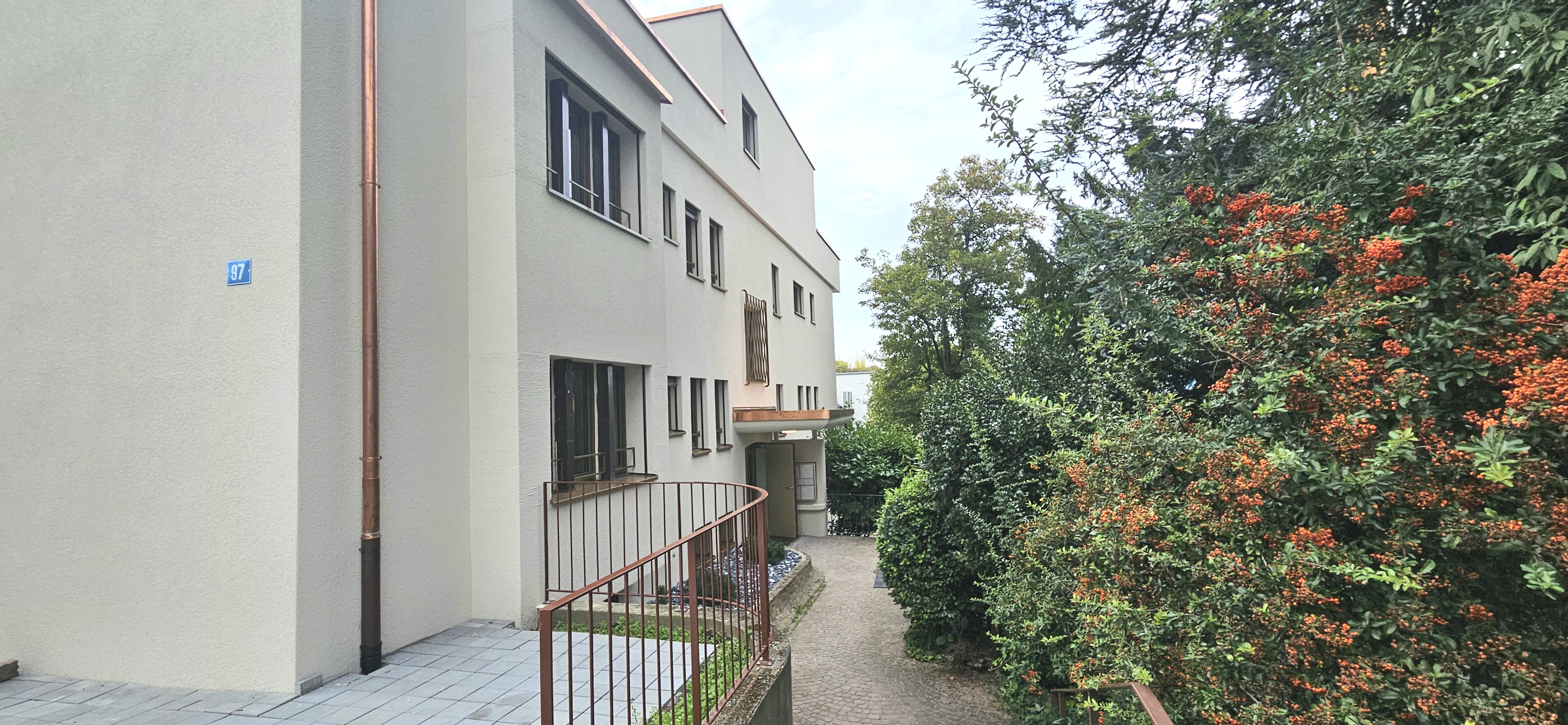 Außenansicht eines Wohngebäudes mit Gartenweg