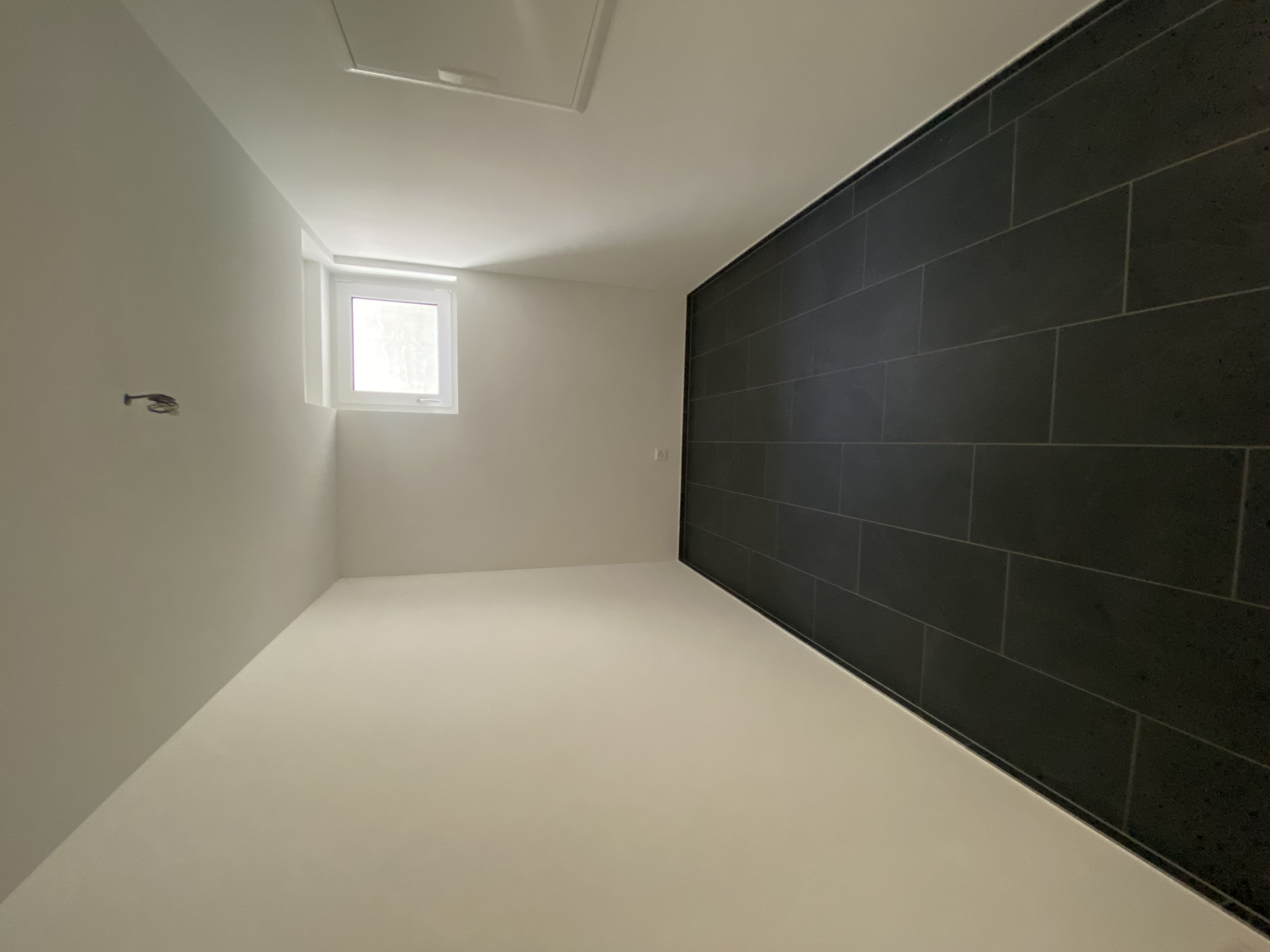Schmaler, leerer Nebenraum mit Fenster