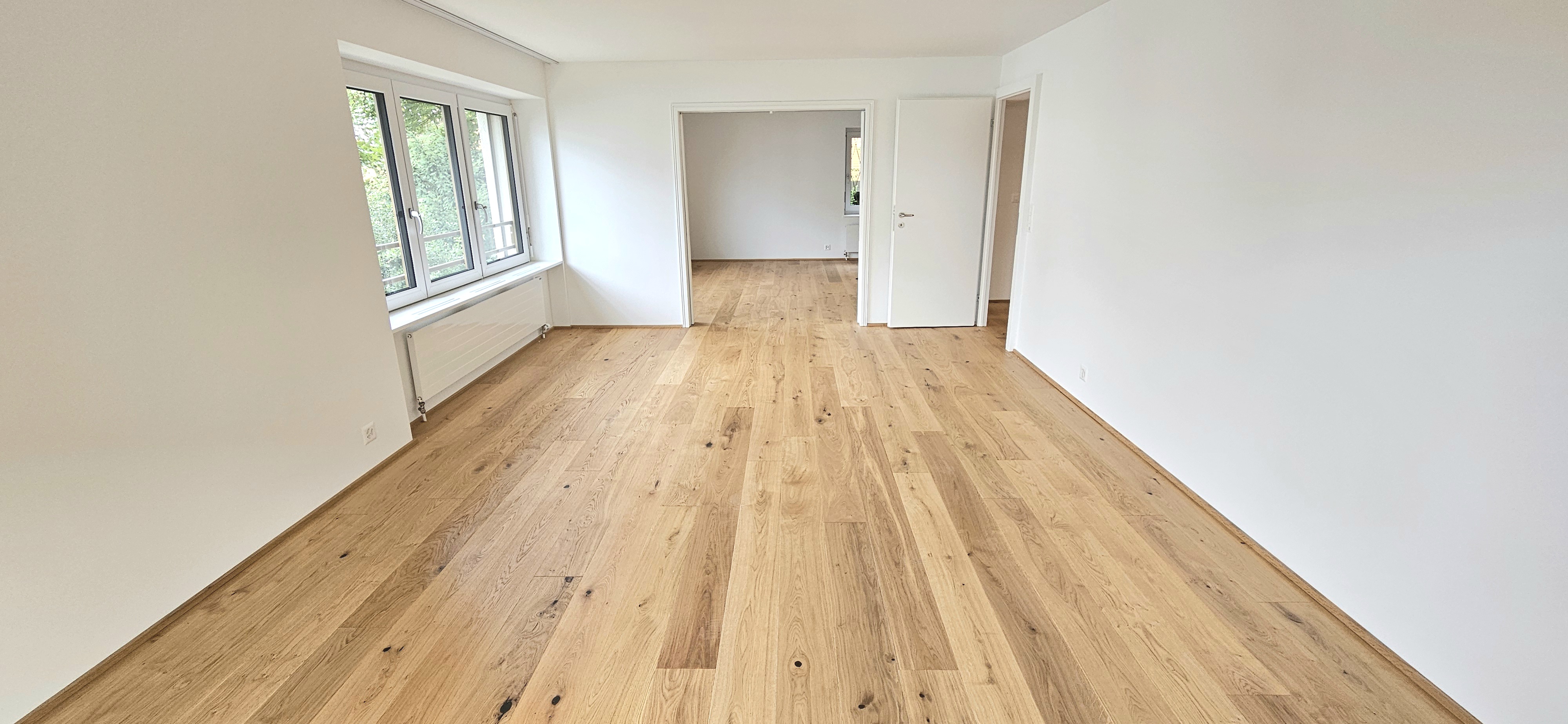 Heller leerer Wohnraum mit Parkettboden
