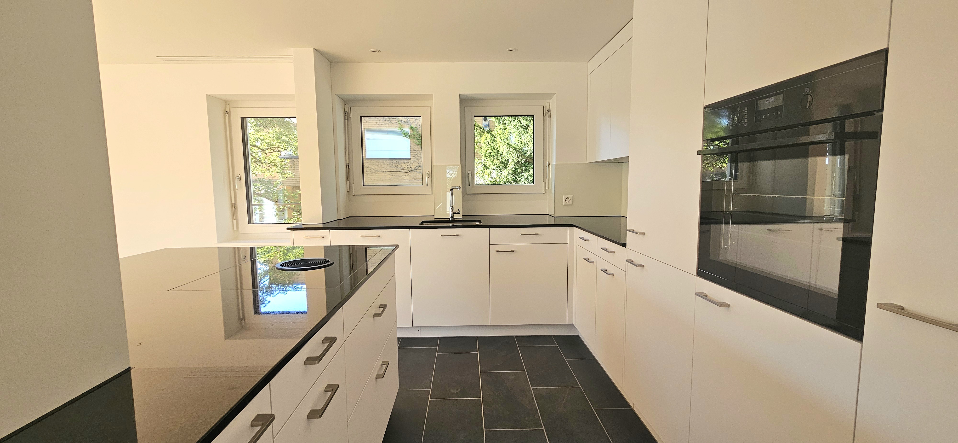 Moderne, helle Küche mit Insel und Fensterfront